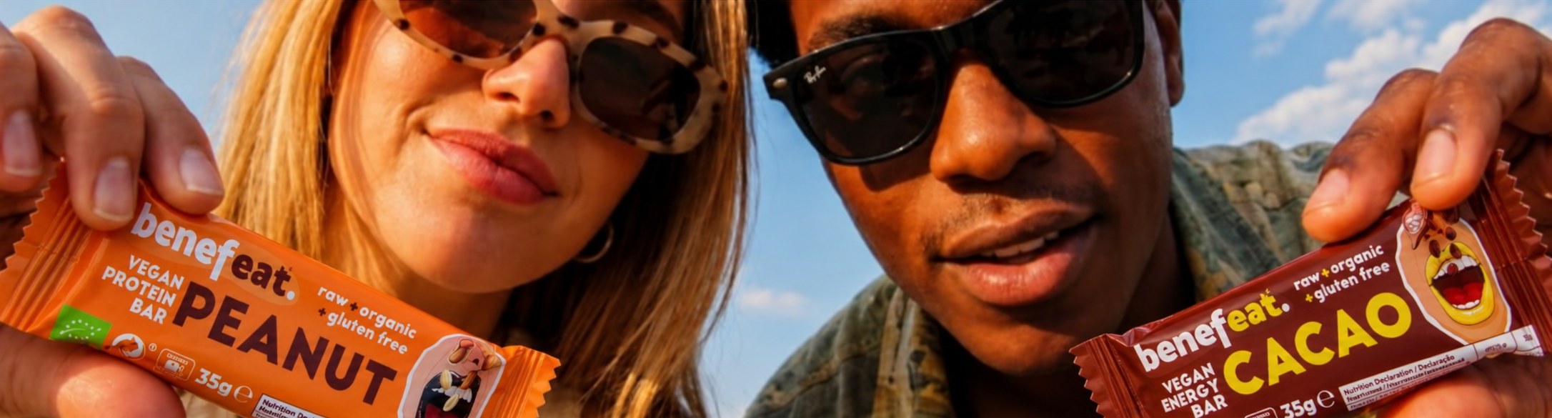 Two people in the sun holding Benefeat Peanut and Cacao bars